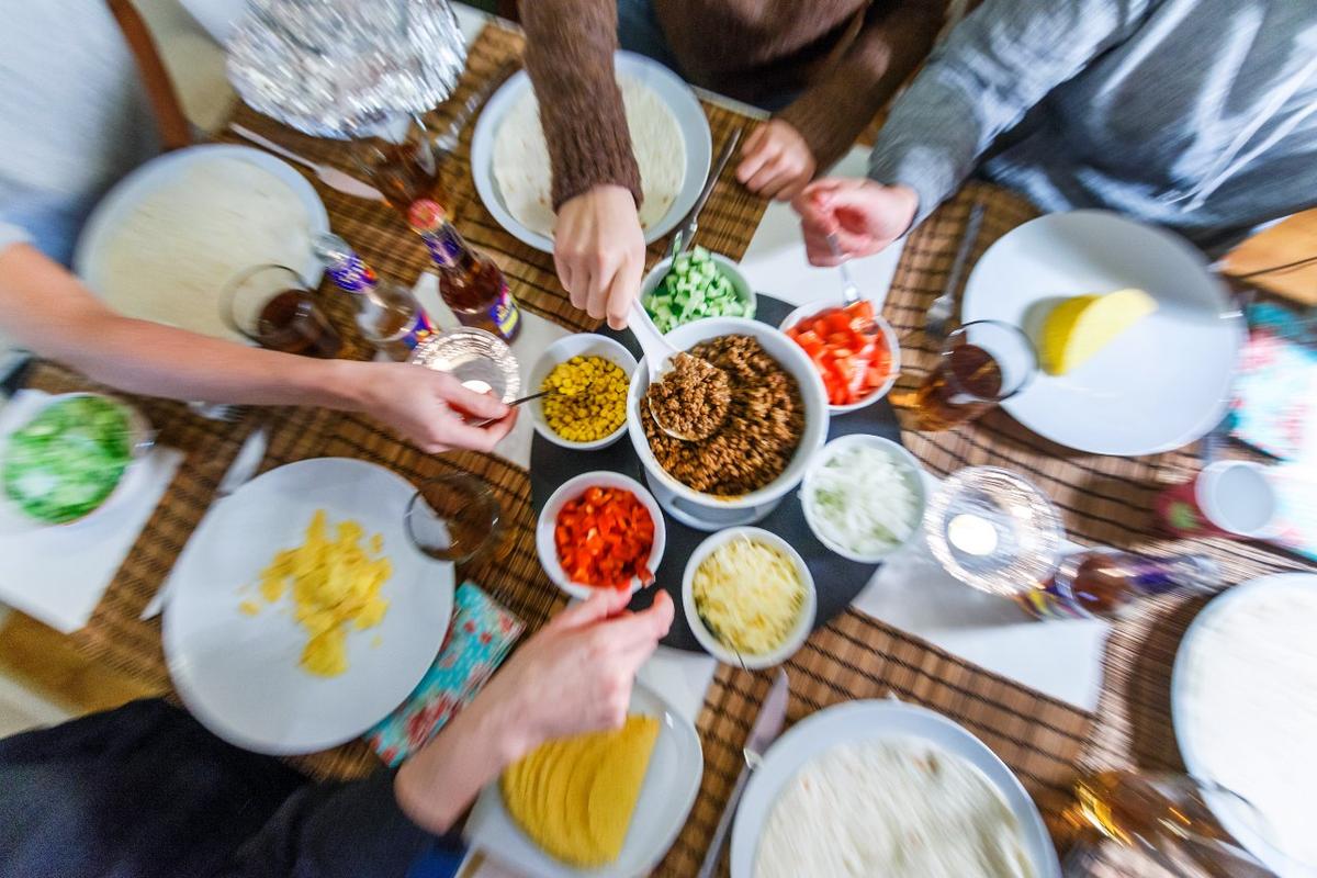 Människor sitter runt ett bord och äter tacos