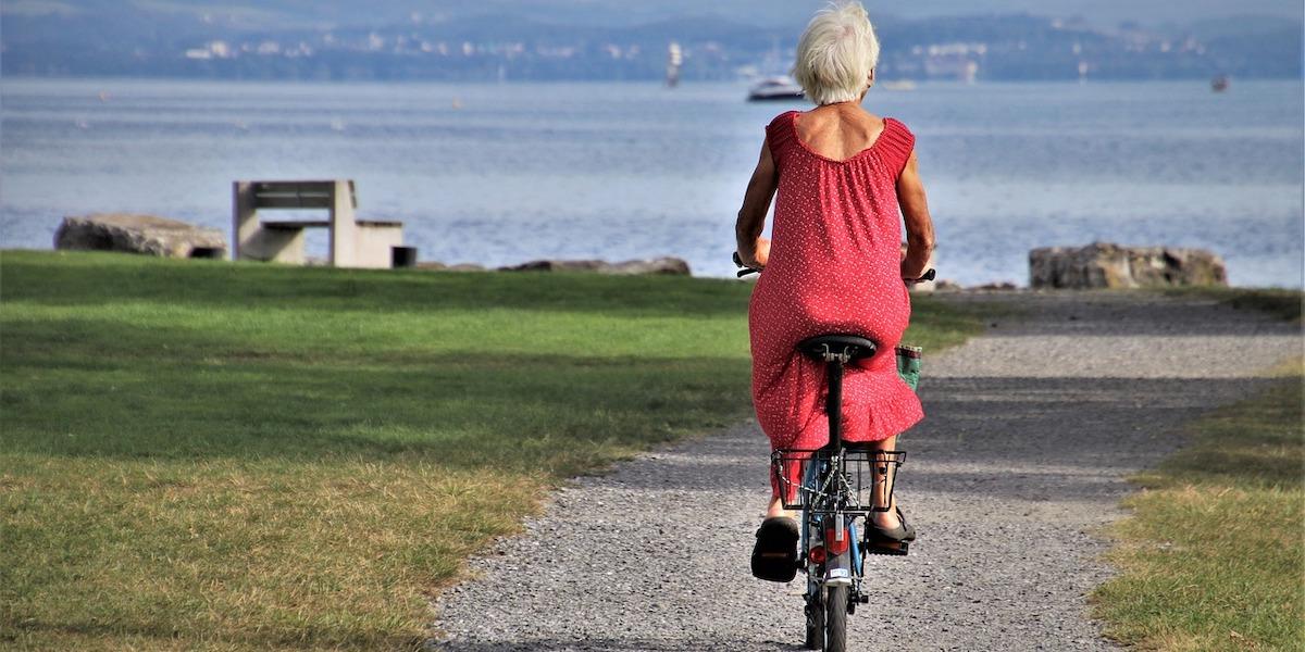En äldre kvinna cyklar. En gång om året reser hon ut som volontär och det har gett henne ett helt nytt perspektiv på sin pensionärstillvaro