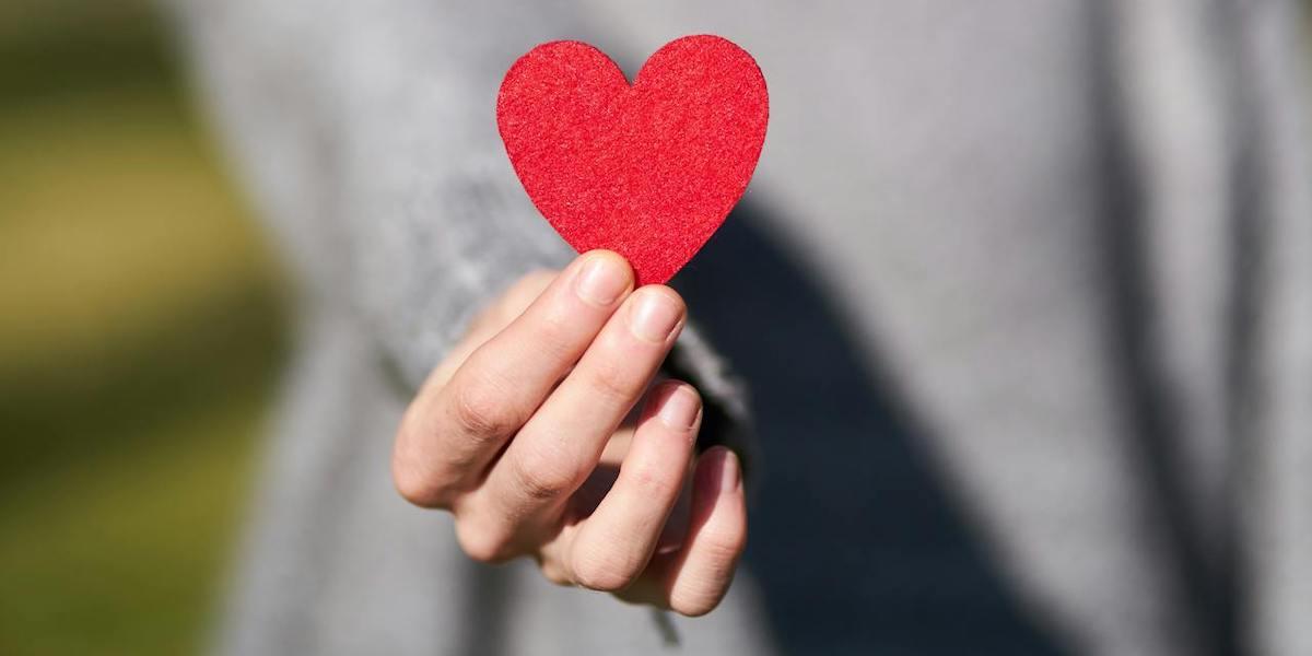En kvinna håller fram ett rött hjärta. Vet du hur gammalt ditt hjärta är och behöver du veta det?