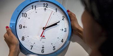 En kvinna ställer om klockan. Sommartid infördes för att spara el men fyller knappast längre den funktionen, i stället påverkar den vårt beteende på ett ohälsosamt sätt