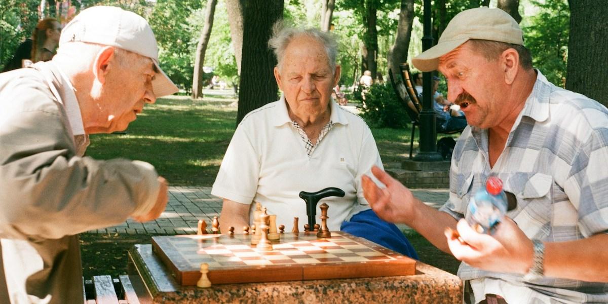 Tre äldre män spelar schack. Sociala kontakter och umgänge med andra är en av de livsstilsfaktorer som kan förbättra hjärnans hälsa och funktion hos människor med tidig Alzheimers sjukdom