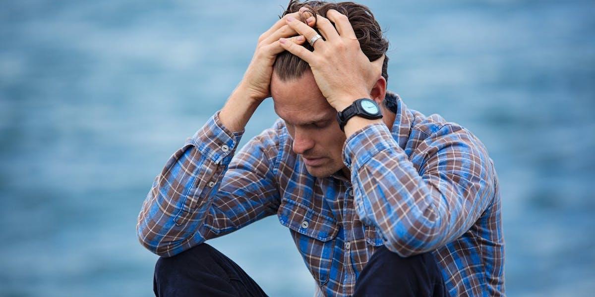 En man har migrän. Migrän kan utlösas av flera saker, bland annat av att stress släpper i samband med ledighet. Så här kan du undvika det