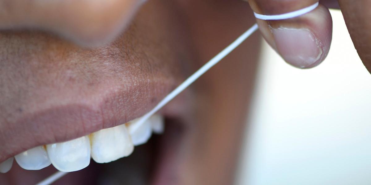 En person använder tandtråd. PFAS finns i allt från tandtråd till livsmedelsförpackningar och nu har det visa sig att dessa farliga evighetskemikalier kan ta sig in i vår kropp via huden