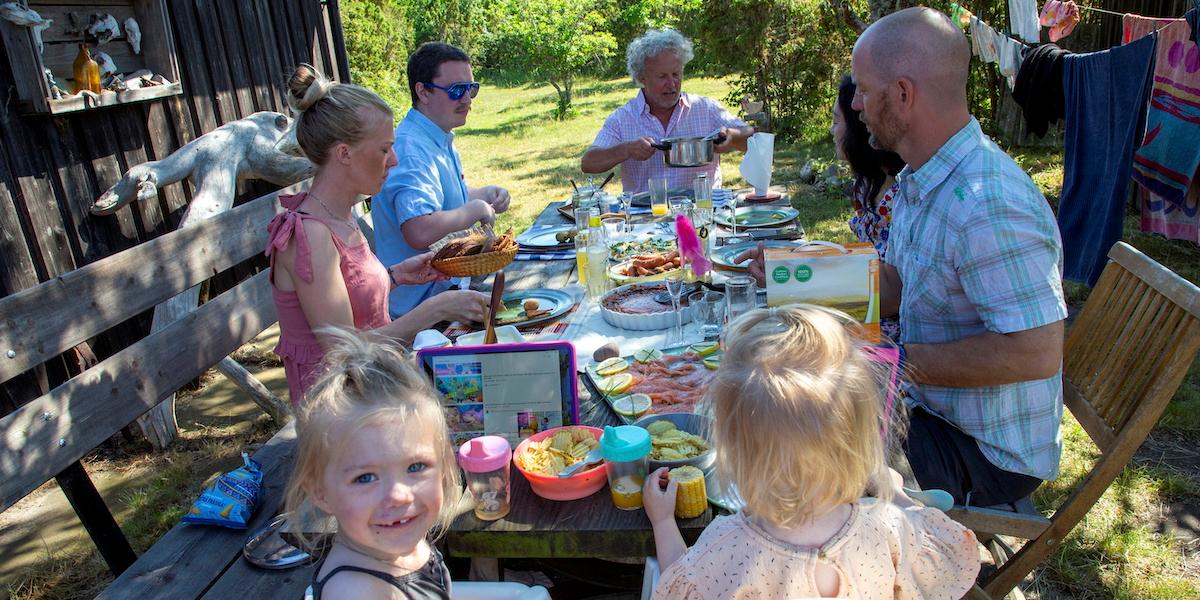 En familj äter midsommarmat. Maten till midsommarfirandet kostar i år bara 0,4 procent mer än det gjorde förra året.