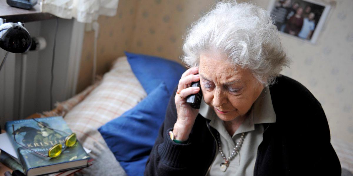 En äldre kvinna talar i telefon. Antalet anmälningar om telefonbedrägerier mot äldre har minskat i år.