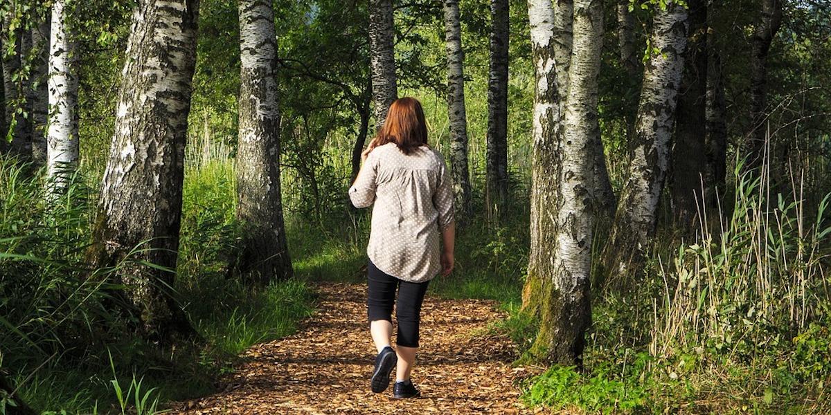 En ensam kvinna på promenad i skogen. En ny studie visar att ensamhet och social isolering påverkar vårt minne negativt