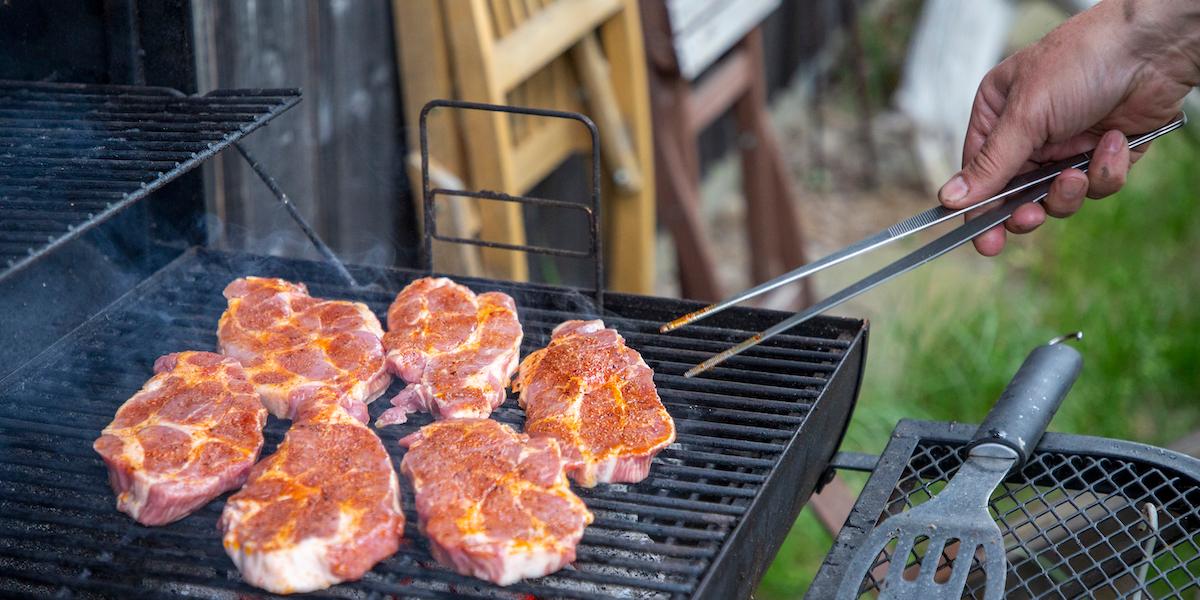 En man grillar kött. För mycket kött är inte bra för hälsan, men många män kopplar kött till maskulinitet, styrka och kraft och äter mer än de borde