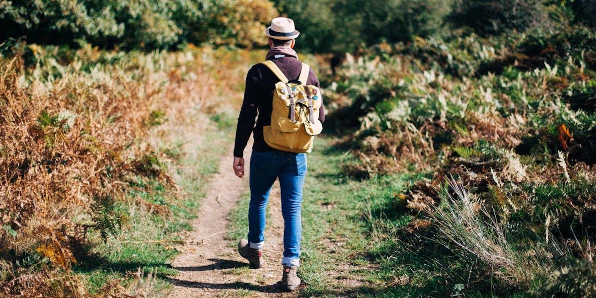 En man promenerar. En ny studie visar att du bränner mer kalorier om du tar pauser när du går än om du går under hela din promenad utan att stanna