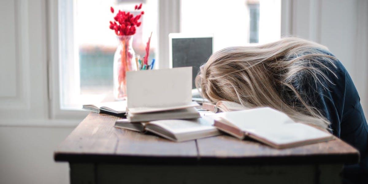 En utmattad kvinna har somnat med huvudet på bordet. De flesta som drabbas av stressrelaterade sjukskrivningar är kvinnor i kvinnodominerande yrken, kvinnor har dock dubbelt så stor risk att bli sjuka av stress oavsett vilket yrke de har