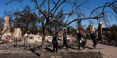 Brandmän från räddningstjänsten i San Bernardino County Fire Department arbetar bland ruinerna i Pacific Palisades i Los Angeles, tisdagen den 14 januari 2025. Förödelsen av bränderna är enorm och även husdjur som hundar och katter drabbas