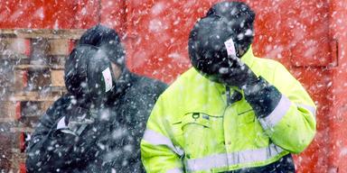 Två byggjobbare i snöoväder håller hjälmar för ansiktet som skydd. En ny svensk studie visar inom vilka yrken män har störst risk för självmord och självmordsförsök