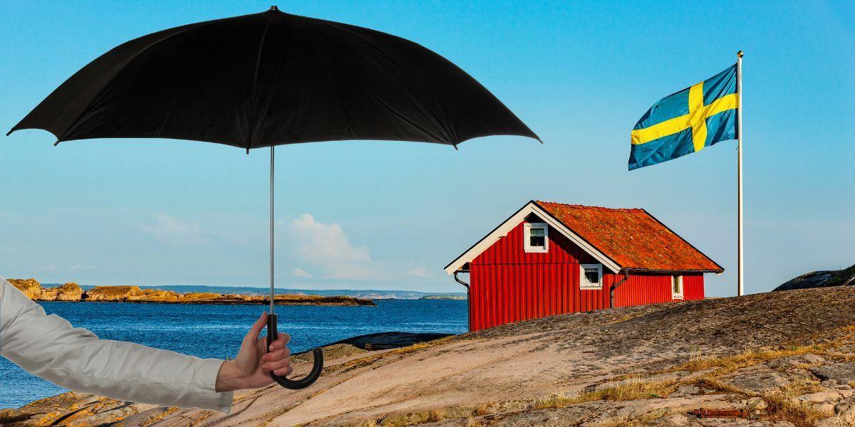 En arm håller fram ett paraply över en bild från skärgården med en röd stuga och svenska flaggan. Glöm inte paraplyet på nationaldagen
