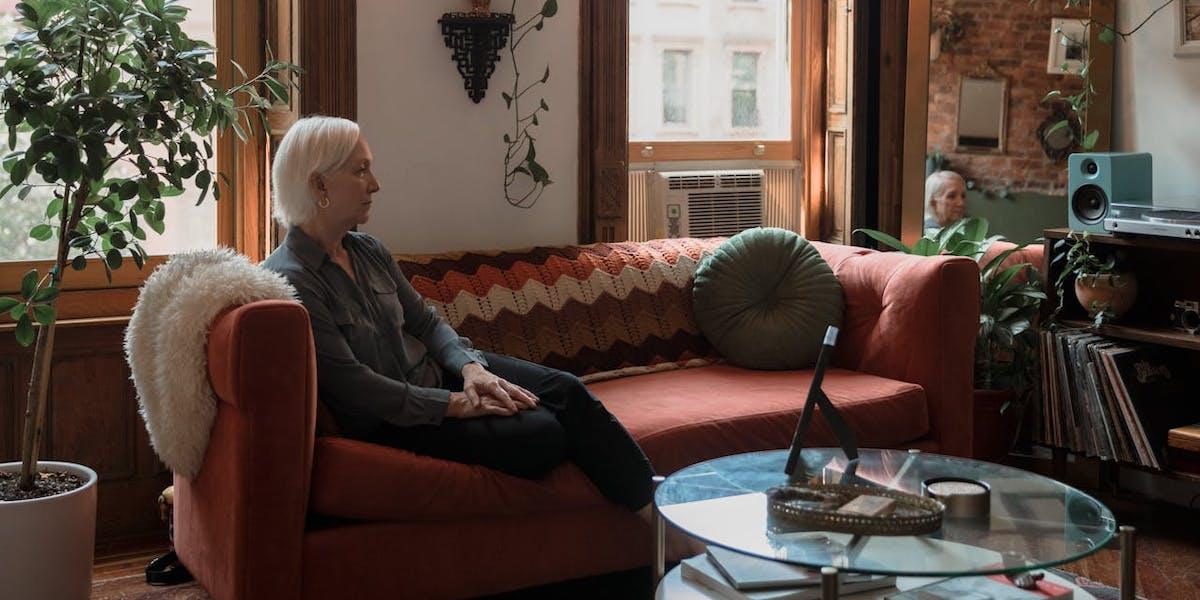 En äldre kvinna sitter i en soffa. En 85-årig kvinna hjälpte själv sin schizofrena son i 26 år eftersom hon inte fick information om att hon kunde få hjälp från kommunen. Kvinnan på bilden har ingenting med texten att göra