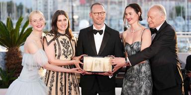 Regissören Joachim Trier, i mitten, vinnare av Grand Prix för filmen "Sentimental Value", med, från vänster, Elle Fanning, Inga Ibsdotter Lilleaas, Renate Reinsve och Stellan Skarsgård vid prisutdelningen på den 78:e internationella filmfestivalen i Cannes, södra Frankrike, den 24 maj 2025.