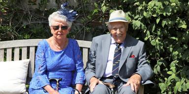 Ett finklätt äldre par sitter på en parksoffa. Statistik visar att allt fler svenska pensionärer gifter sig