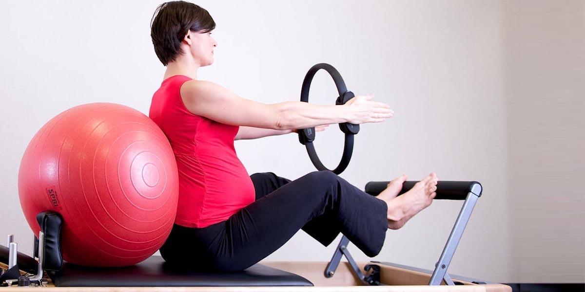 En kvinna tränar pilates på en reformer