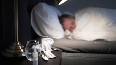 en person ligger nerbäddad sjuk