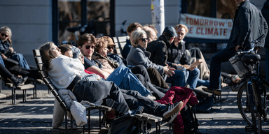 Vår och människor på bänkar i solen.