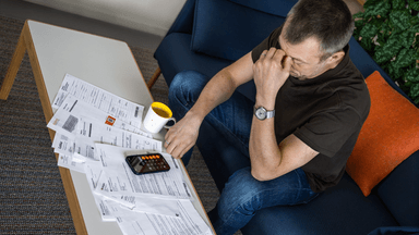 En man som går igenom sin ekonomi och sina bankpapper.