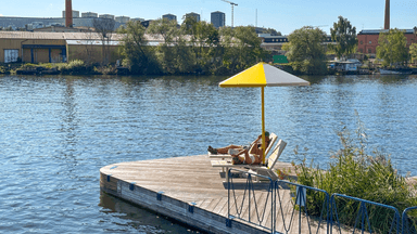 Två personer på resa på en brygga i solen.