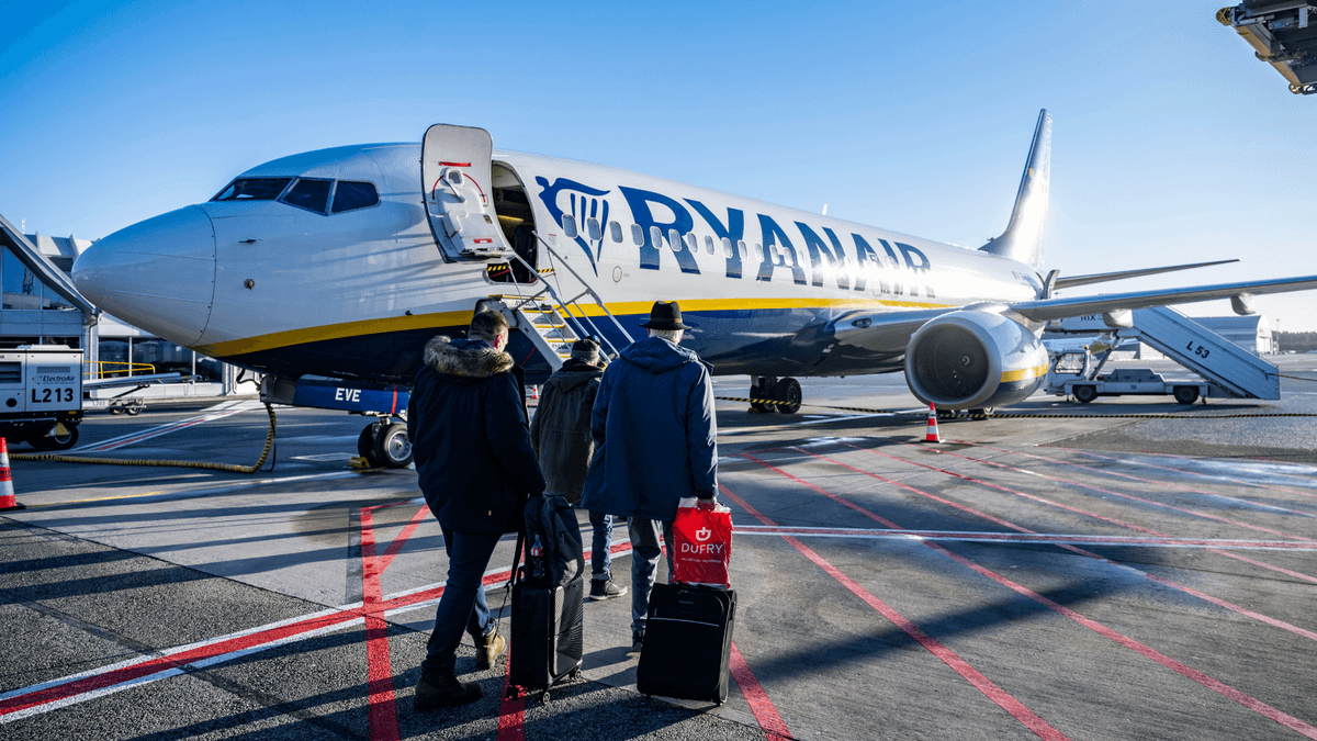 Ett flygplan som tillhör Ryanair och passagerare på väg mot det.